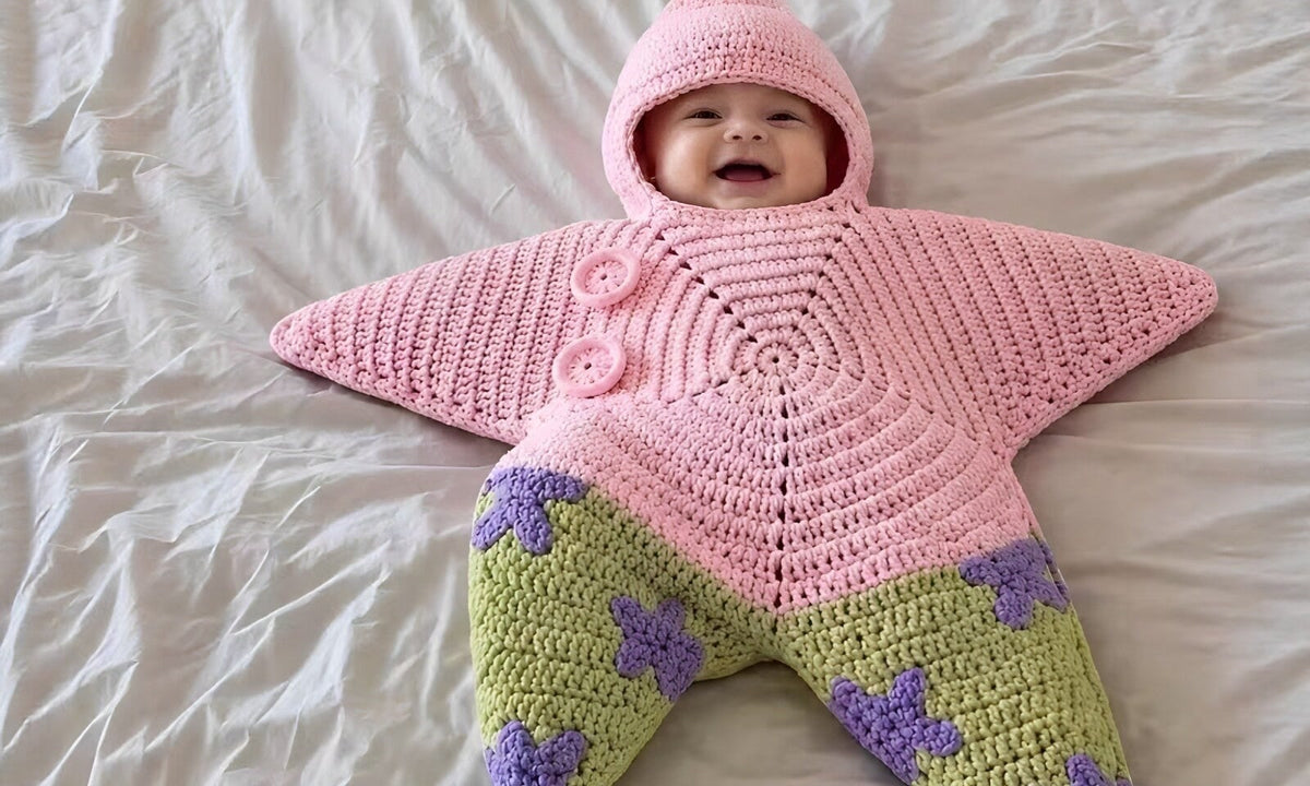 Baby laughing in the Pink Little Starfish knit romper with green spotted legs